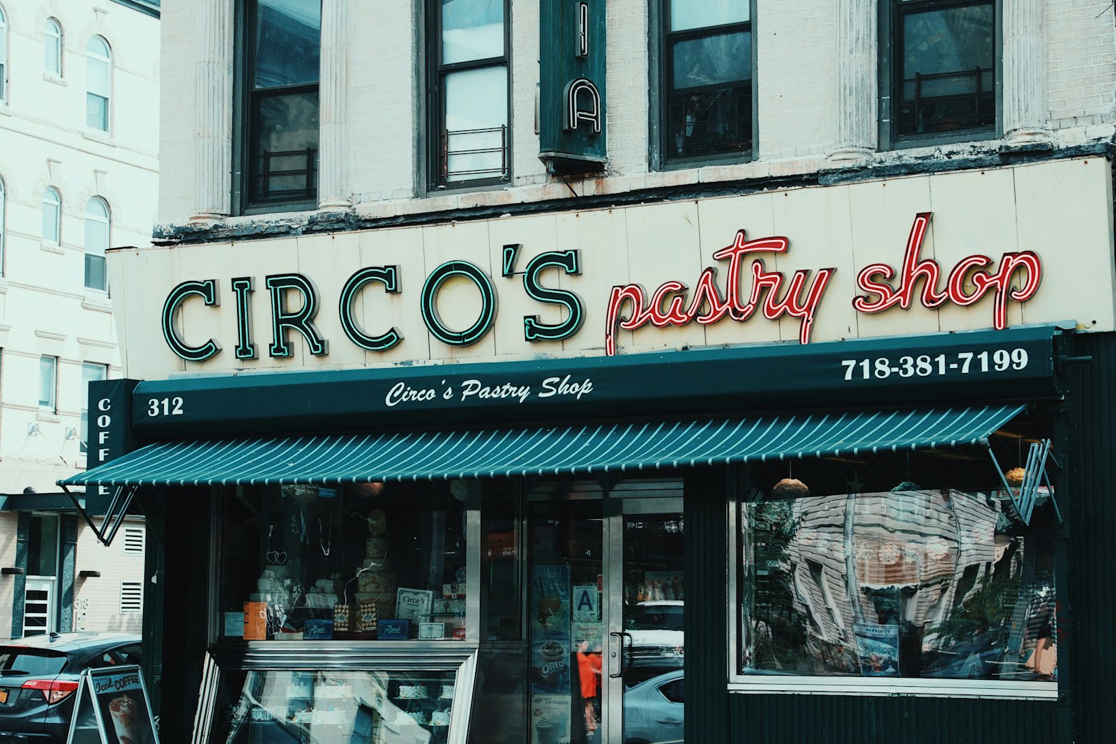 An independent local pastry shop storefront with a teal awning